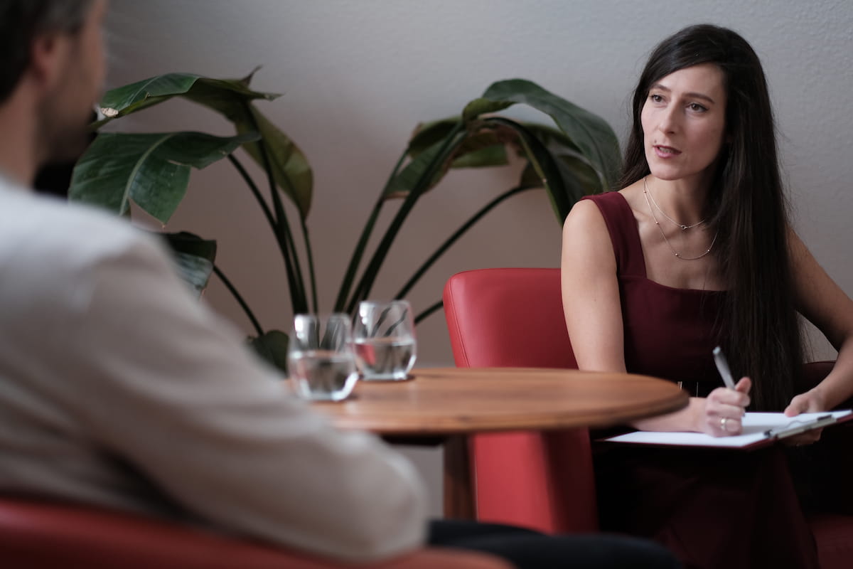 Jenny Christoffel, Beziehungscoach & Paarberaterin online und in Hilden bei Düsseldorf, sitzt mit einem Klienten am Tisch und führt eine Coachingsitzung im Rahmen ihres Programms „Bleiben oder gehen“ – empathisch, klar und strukturiert.