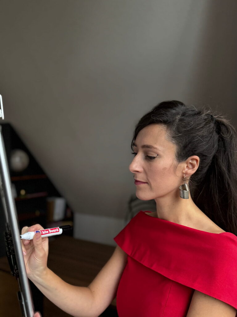 Jenny Christoffel, erfahrene Beziehungscoach & Paarberaterin online und in Hilden bei Düsseldorf, steht am Flipchart und blickt konzentriert darauf. Sie begleitet Frauen und Männer im Coaching-Prozess „Bleiben oder gehen“, um Klarheit und innere Ruhe in Beziehungskrisen zu finden und die Entscheidung zu fällen die Beziehung weiterzuführen oder nicht.