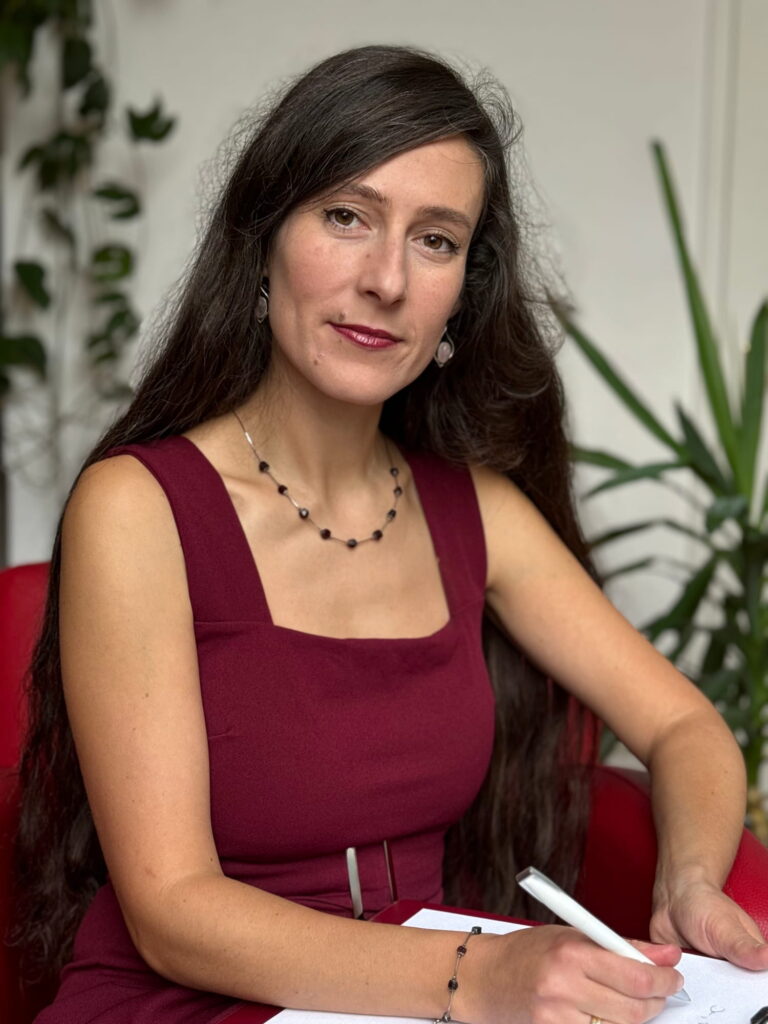 Jenny Christoffel, Beziehungscoach & Paarberaterin online und in Hilden bei Düsseldorf, sitzt und blickt nachdenklich, aber freundlich in die Kamera. Das Bild steht für Einfühlungsvermögen und die Einladung, Beziehung neu zu betrachten und Schritte zur Veränderung zu wagen.