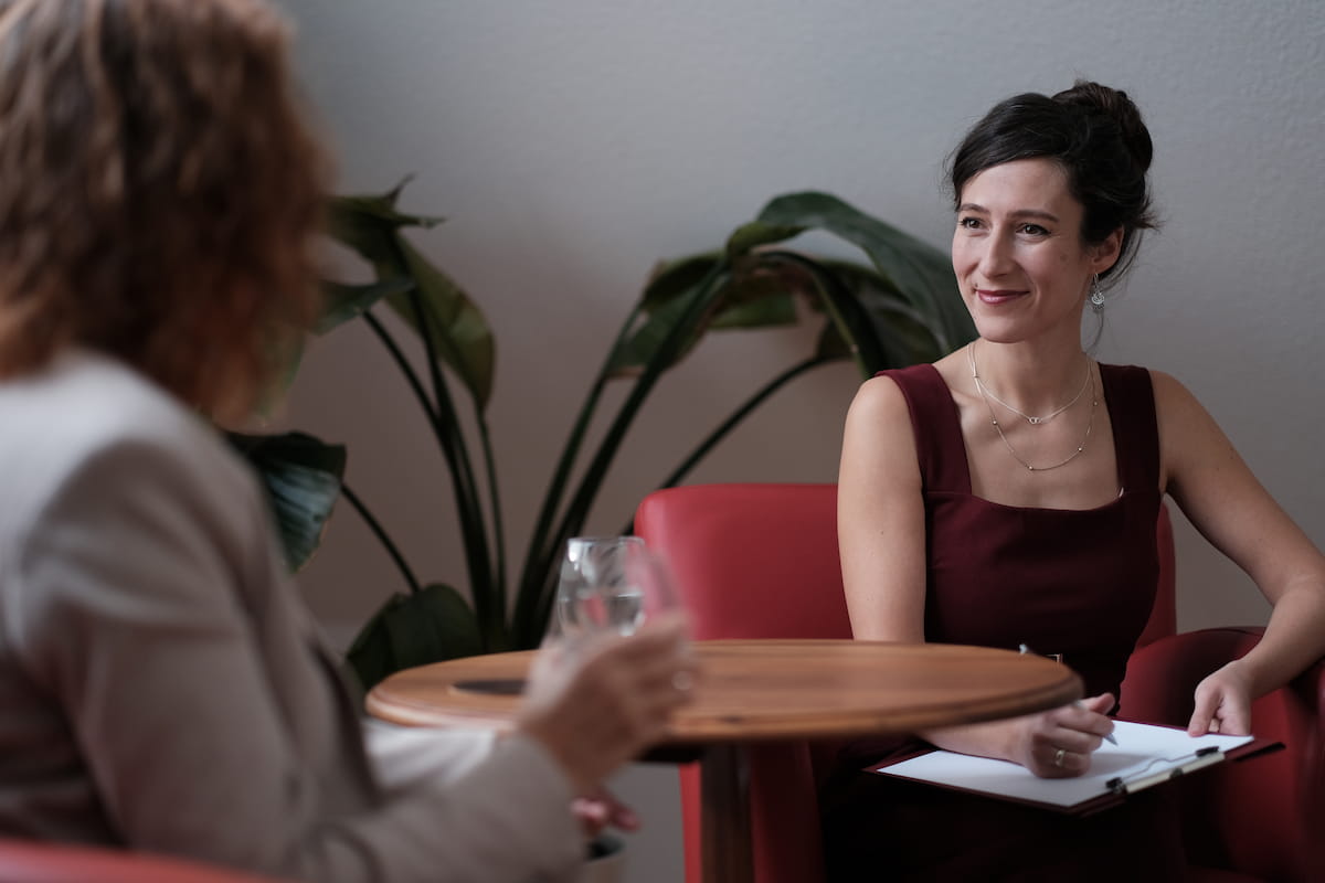 Trennung in Würde Jenny Christoffel, Beziehungscoach & Paarberaterin online und in Hilden bei Düsseldorf, sitzt mit einer Klientin am Tisch und hört ihr lächelnd zu. Sie befinden sich in Phase 1 „Verstehen“ ihres Coaching-Prozesses „Trennung in Würde“. Sie hilft ihr, Muster, Verletzungen und unausgesprochene Erwartungen zu erkennen.