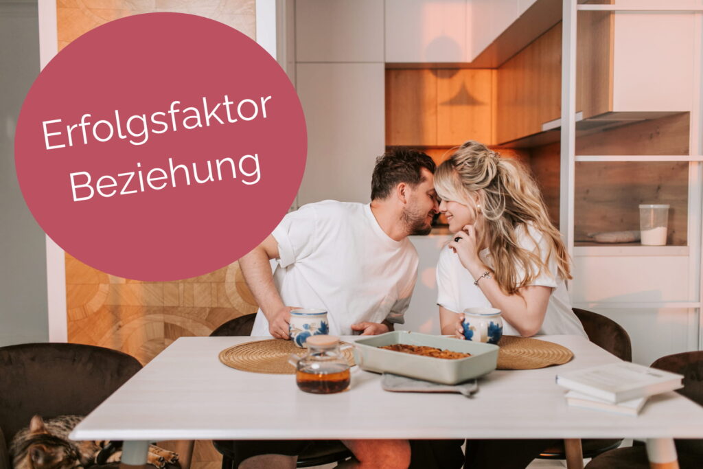 Paar genießt einen innigen Moment am Küchentisch und symbolisiert eine starke Beziehung für Unternehmer:innen und ihre Partner:innen.